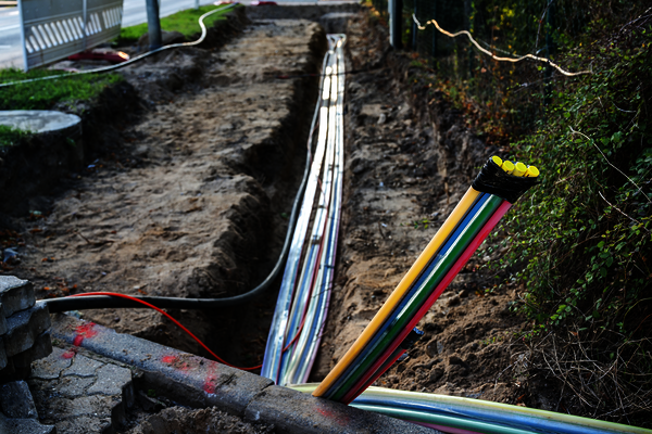 Glasfaser-Baustelle, Telekommunikationsleitungen in Künette Glasfaser werden in Künette verlegt, Baustelle, Telekommunikation