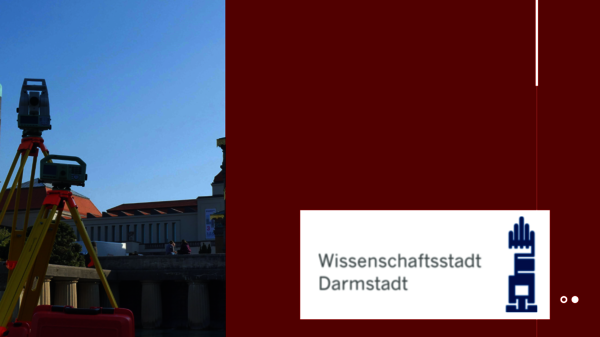 Vermessungsgerät (Totalstation) auf einem Bauplatz mit Gebäuden im Hintergrund; rechts das Logo Wissenschaftsstadt Darmstadt mit einem blauen Turm-Symbol.