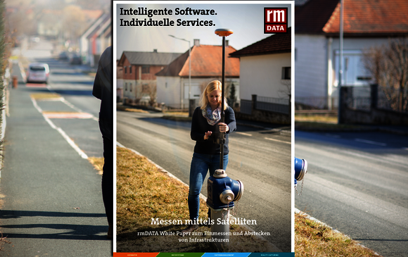 Ein Werbebanner einer IT-Firma steht vor einer Straßenszene; eine Frau hält ein Vermessungsgerät vor sich. Auf dem Banner stehen die Slogans: "Intelligente Software. Individuelle Services." und "Messen mittels Satelliten".